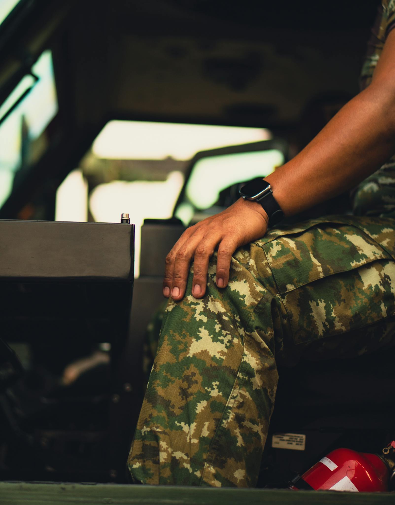 Close-up of military personnel in camouflage inside an armored vehicle.
